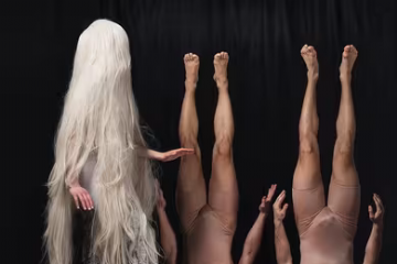 immagine due uomini capovolti e una persona capelli lunghi biondi