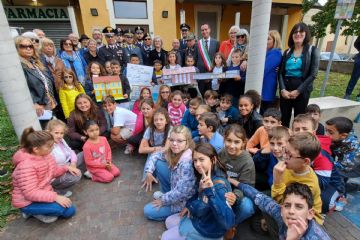 i bambini e le autorità al termine della cerimonia davanti alla vecchia scuola